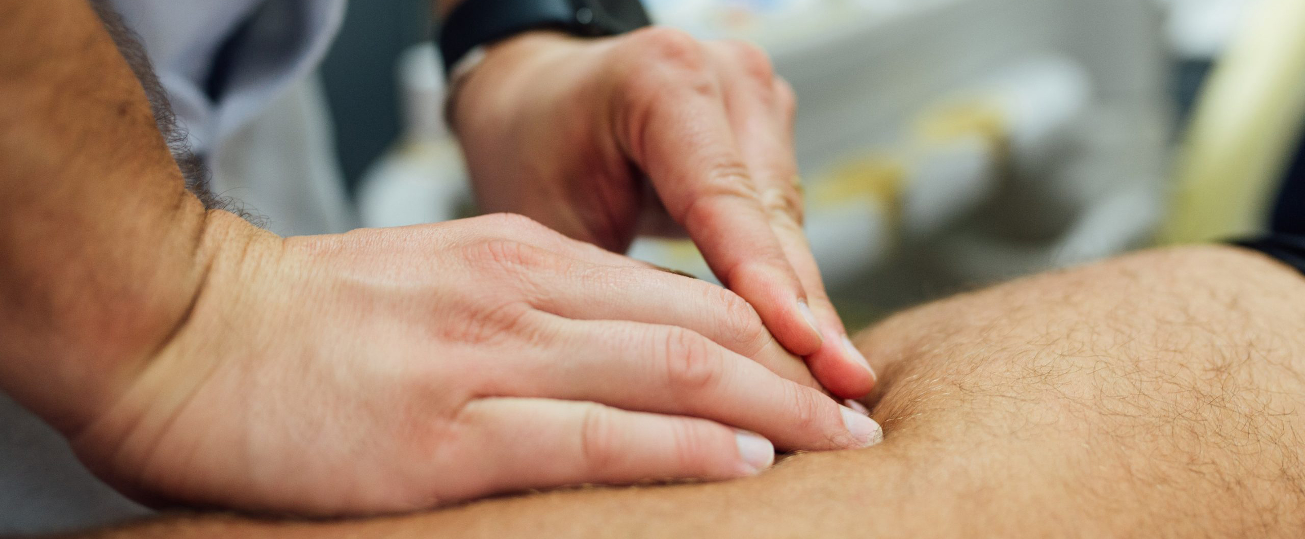 Un fisioterapeuta de Mediesport realiza una exploración con las manos en una pierna