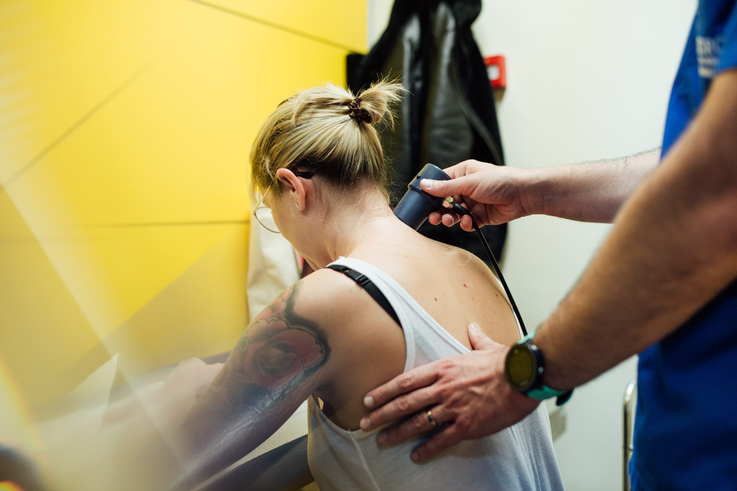 Un fisioterapeuta aplicacia un tratamiento en la espalda de una altleta.