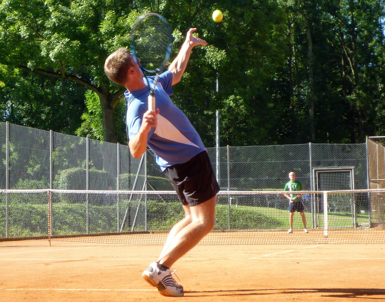 Un jugador de tenis a punto de realizar un saque, realiza un movimiento en eñl que fuerza la muñeca izquierda